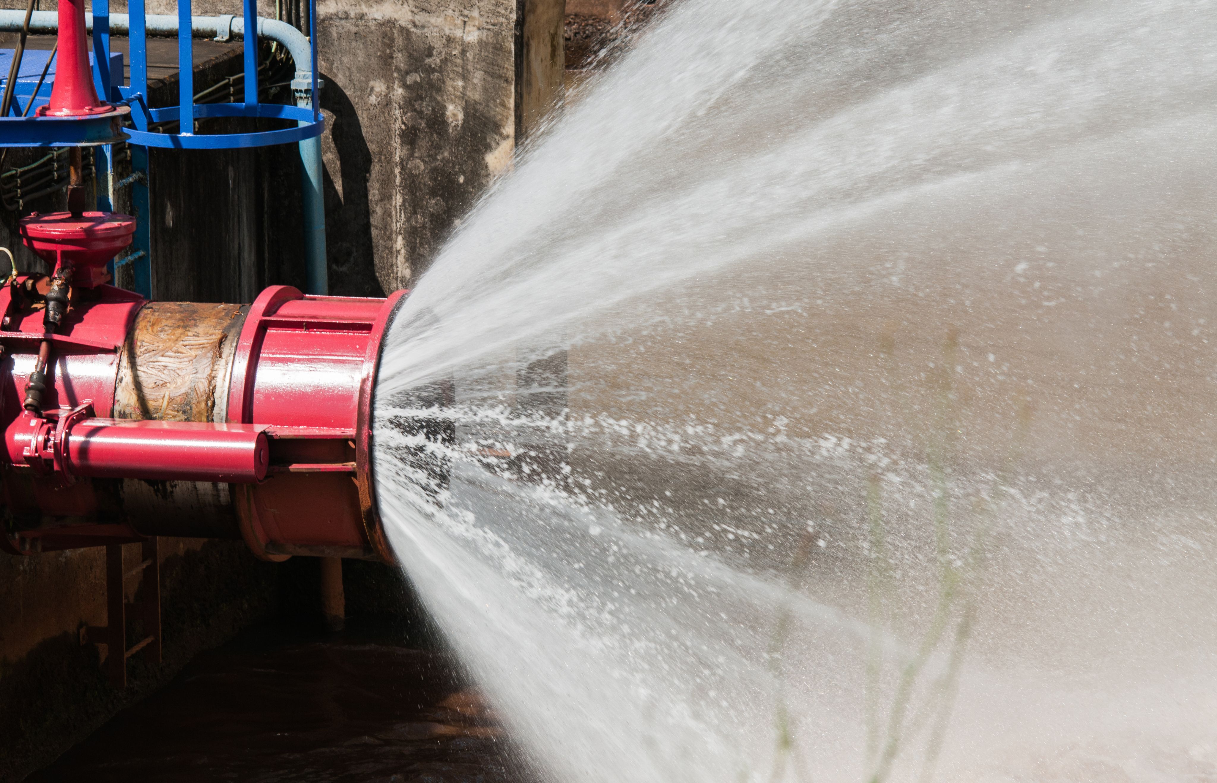 Krachtige waterstraal uit een rode brandkraan