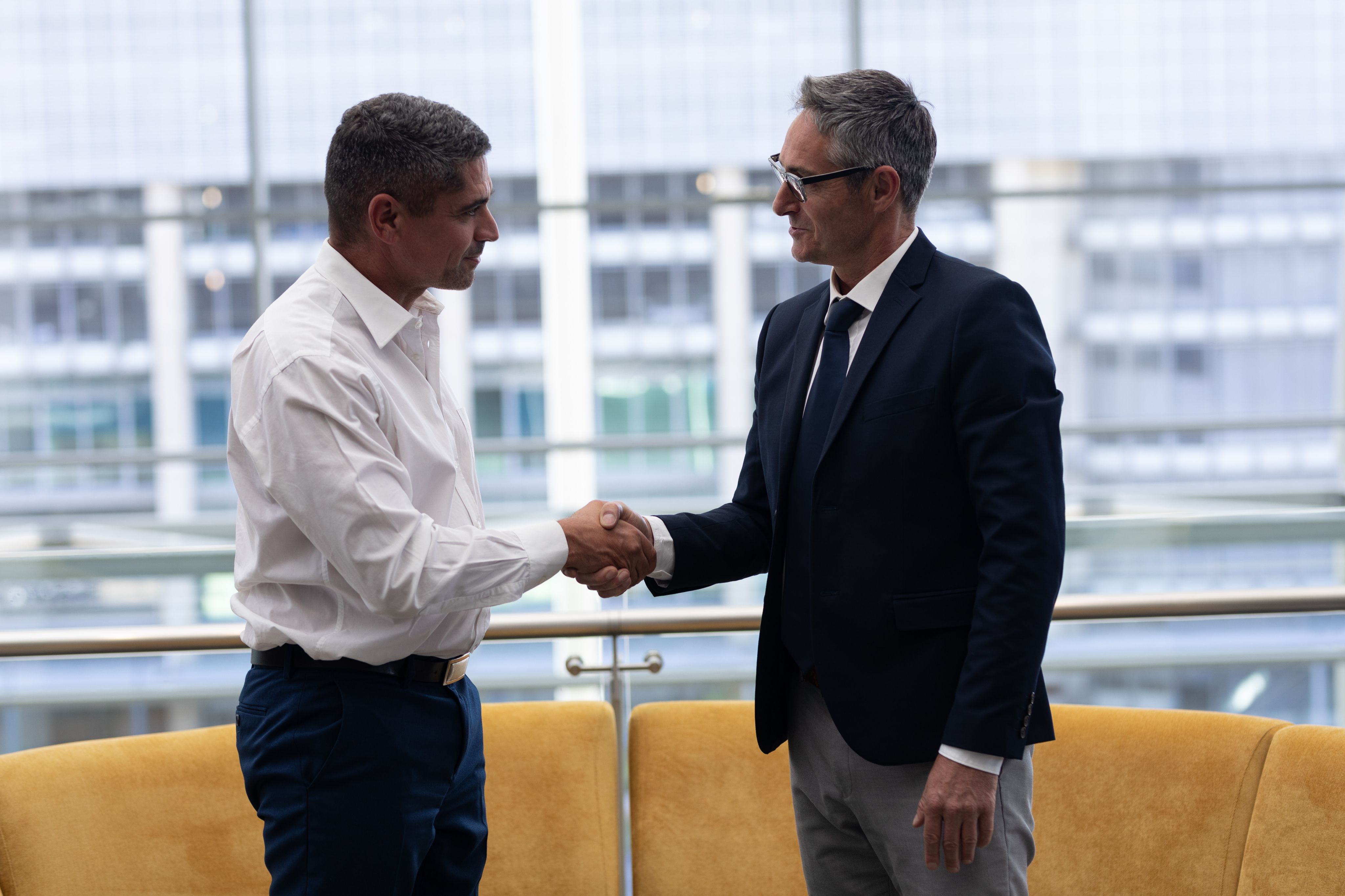 Two people shaking hands in an office building