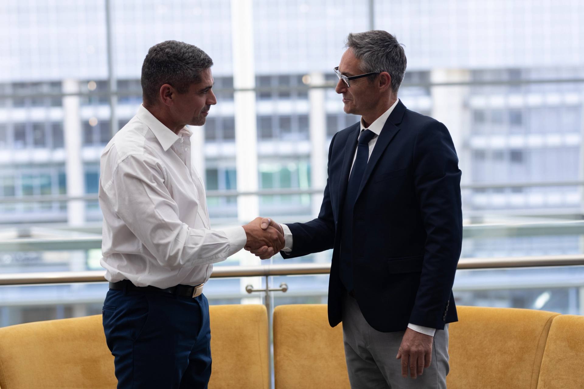 Two people shaking hands in an office building