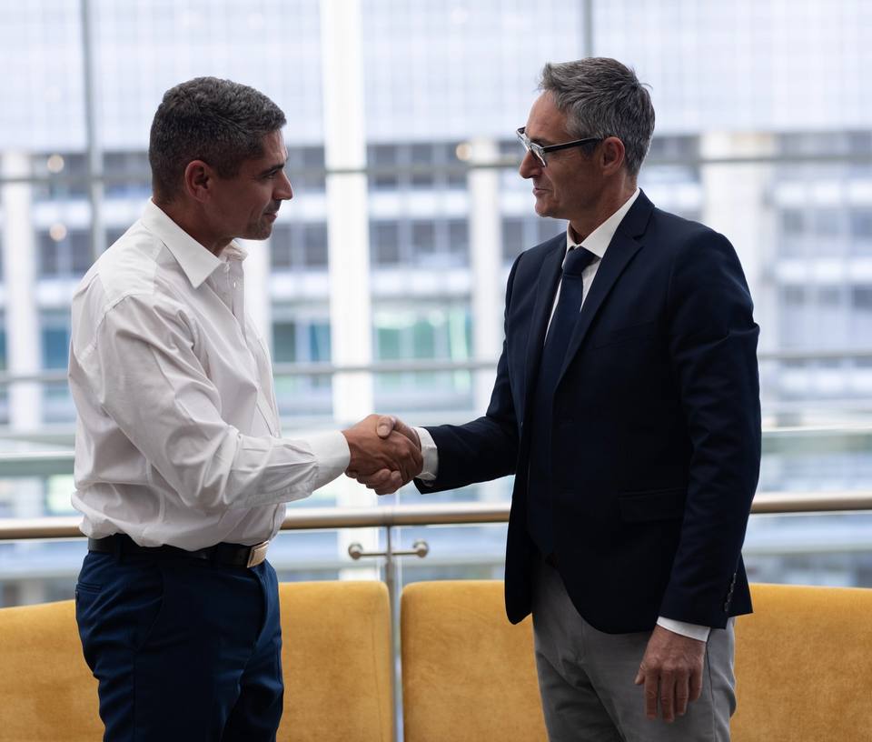Two people shaking hands in an office building