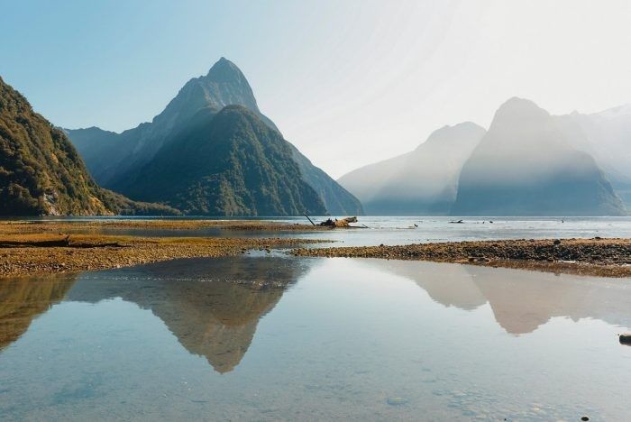 Mountains reflected in still water at low tide