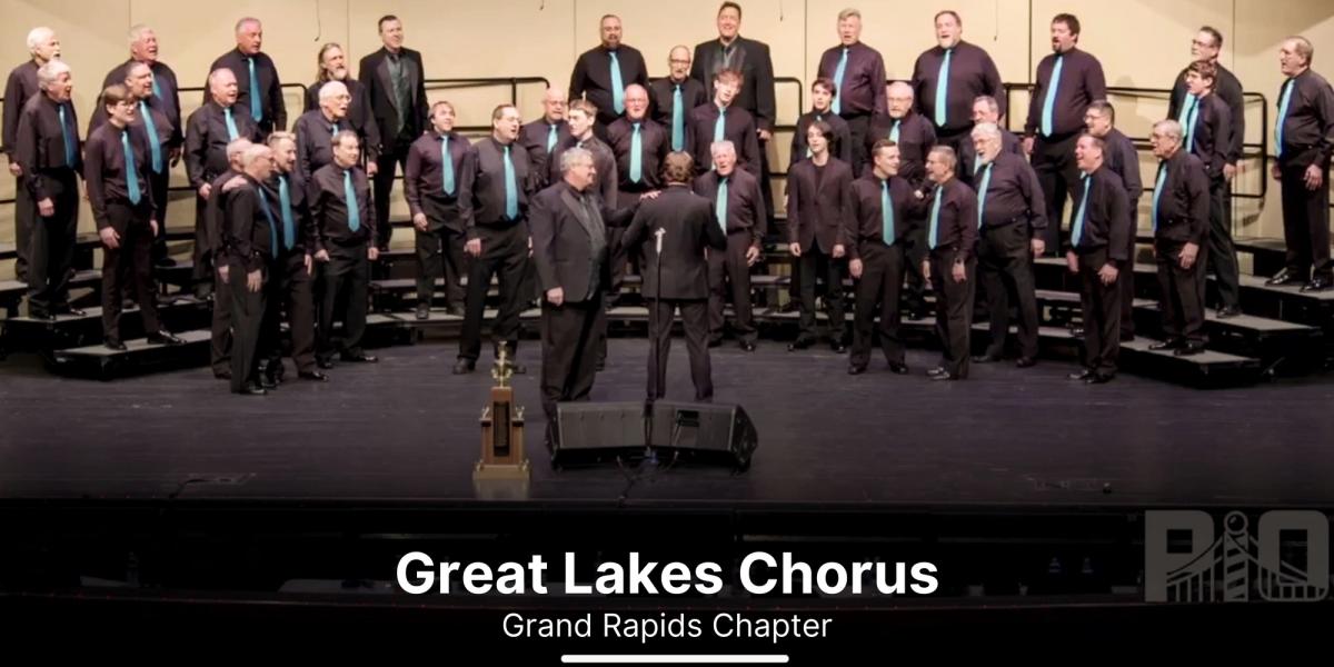 Great Lakes Chorus singing with trophy on stage