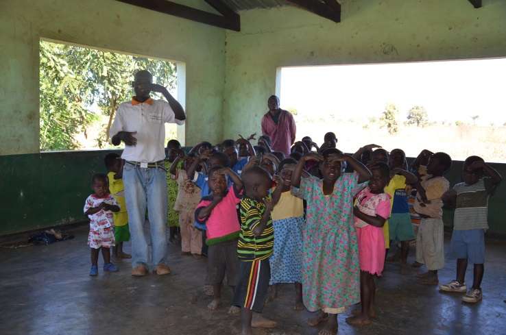 Caregiver teaching the children an action game at Namanyanga CBCC