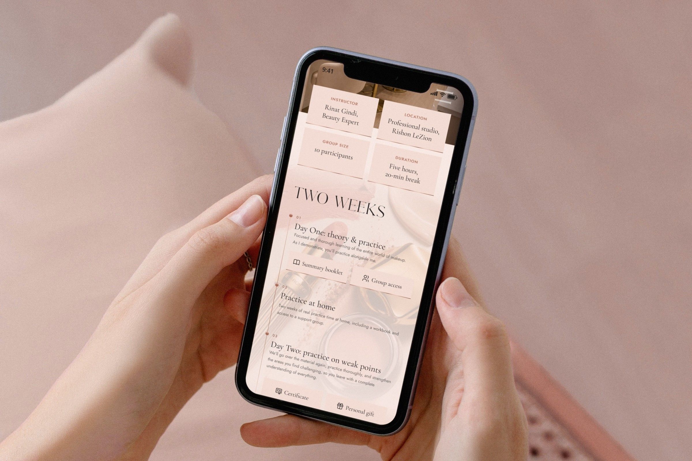 What the course includes, on an iPhone held in two hands against a dusty pink backdrop: the instructor, location, group size and duration cards, then the two-week plan with a summary booklet and group access on day one, practice at home, and a certificate and a personal gift on day two