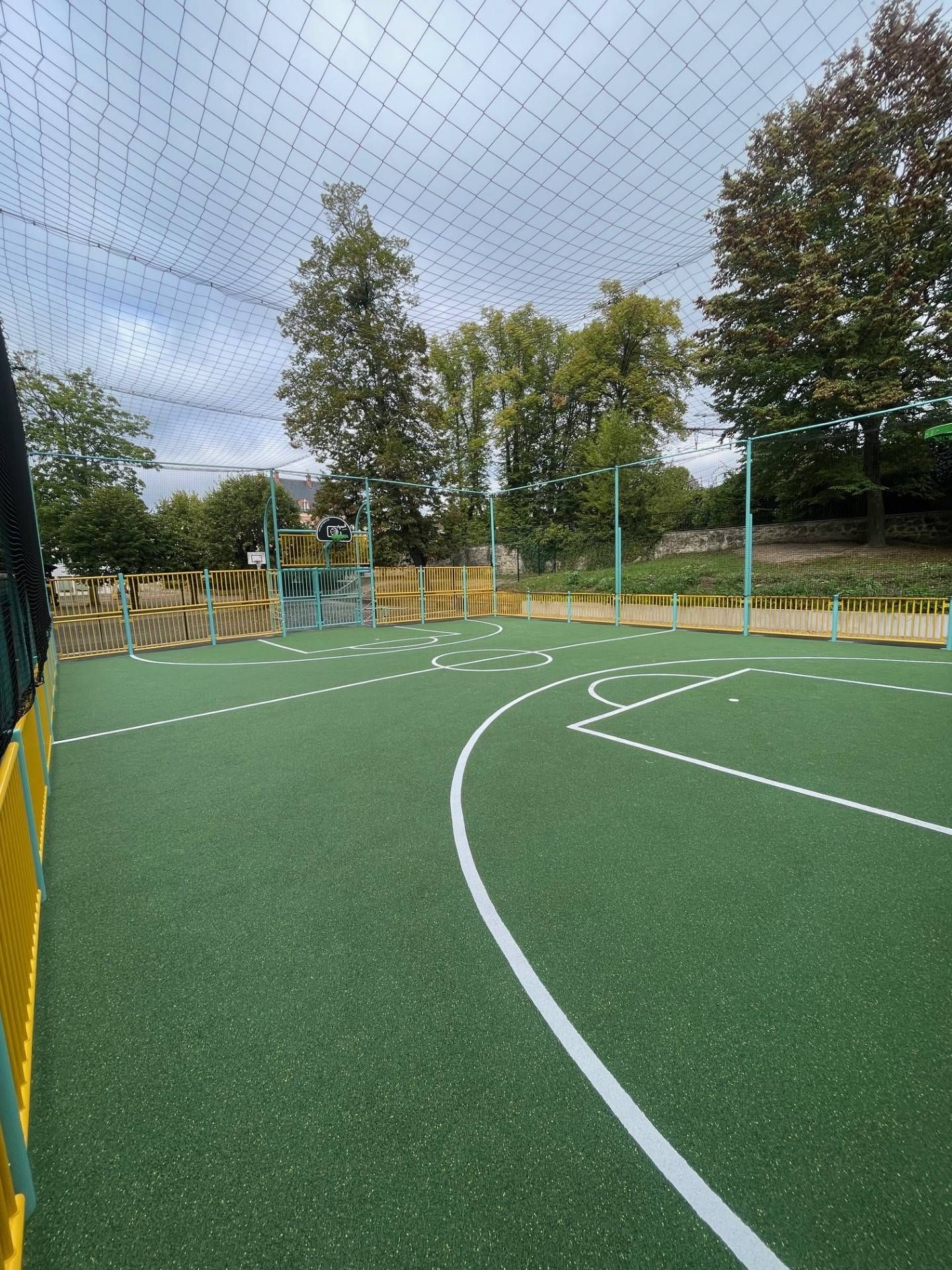 Terrain de basketball avec marquage sportif vert et lignes blanches