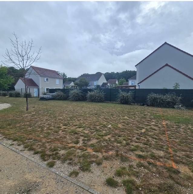 Terrain herbeux délimité avant travaux de rénovation d'une aire de jeux