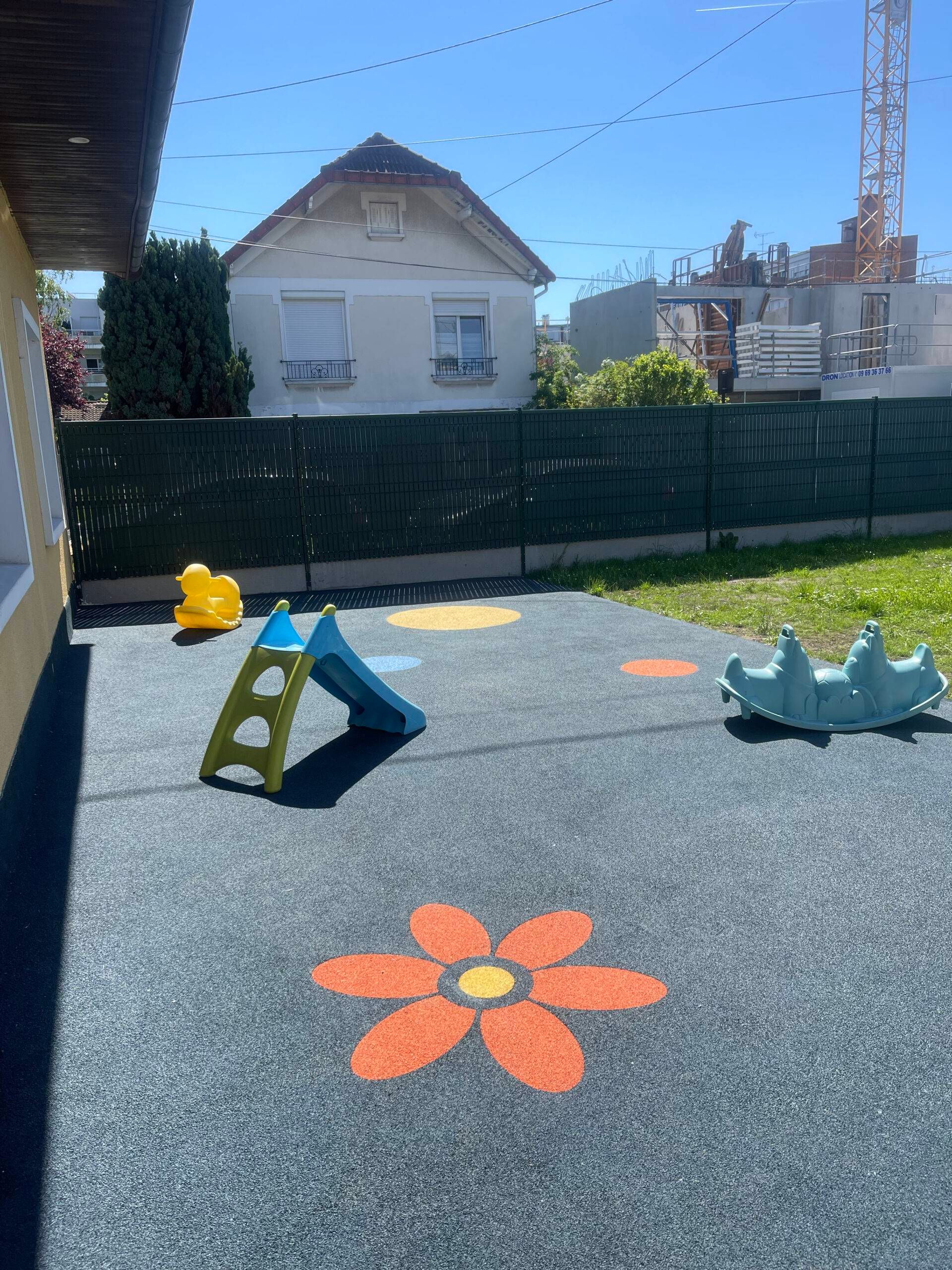 Motif de fleur et ronds colorés sur sol amortissant gris en crèche