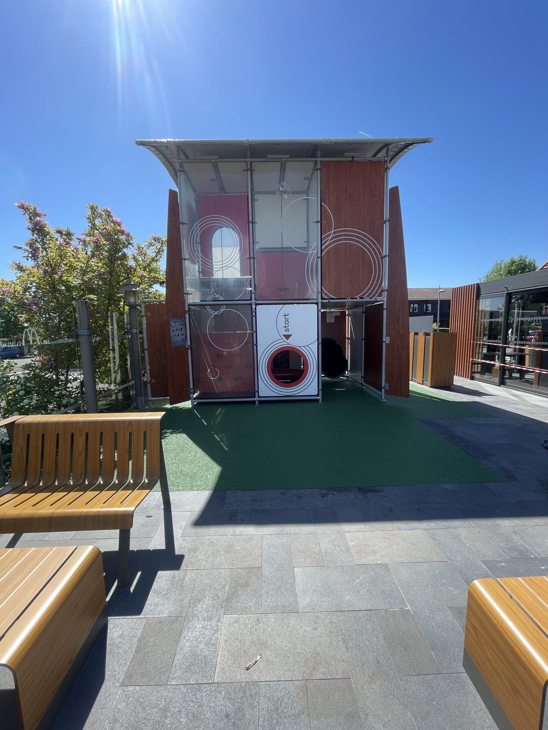 Structure de jeu avec circuits colorés sur sol amortissant vert en terrasse