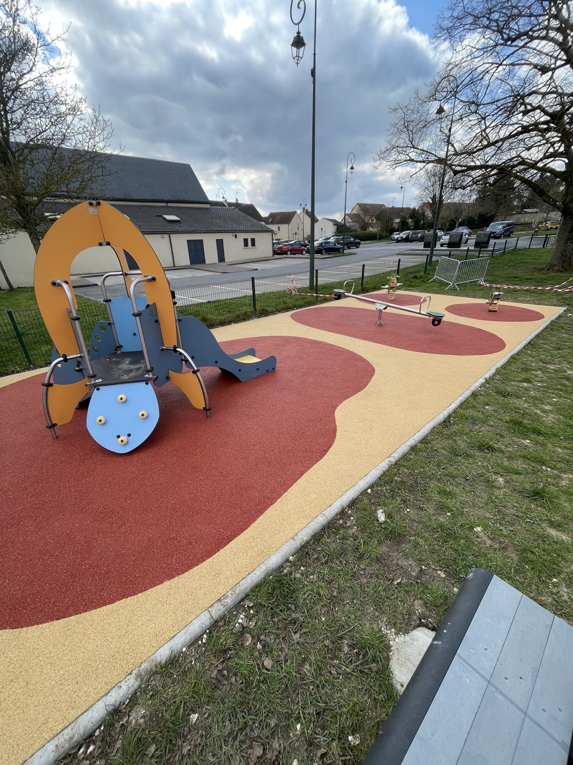 Aire de jeux terminée avec structure fusée, balançoire et sol amortissant