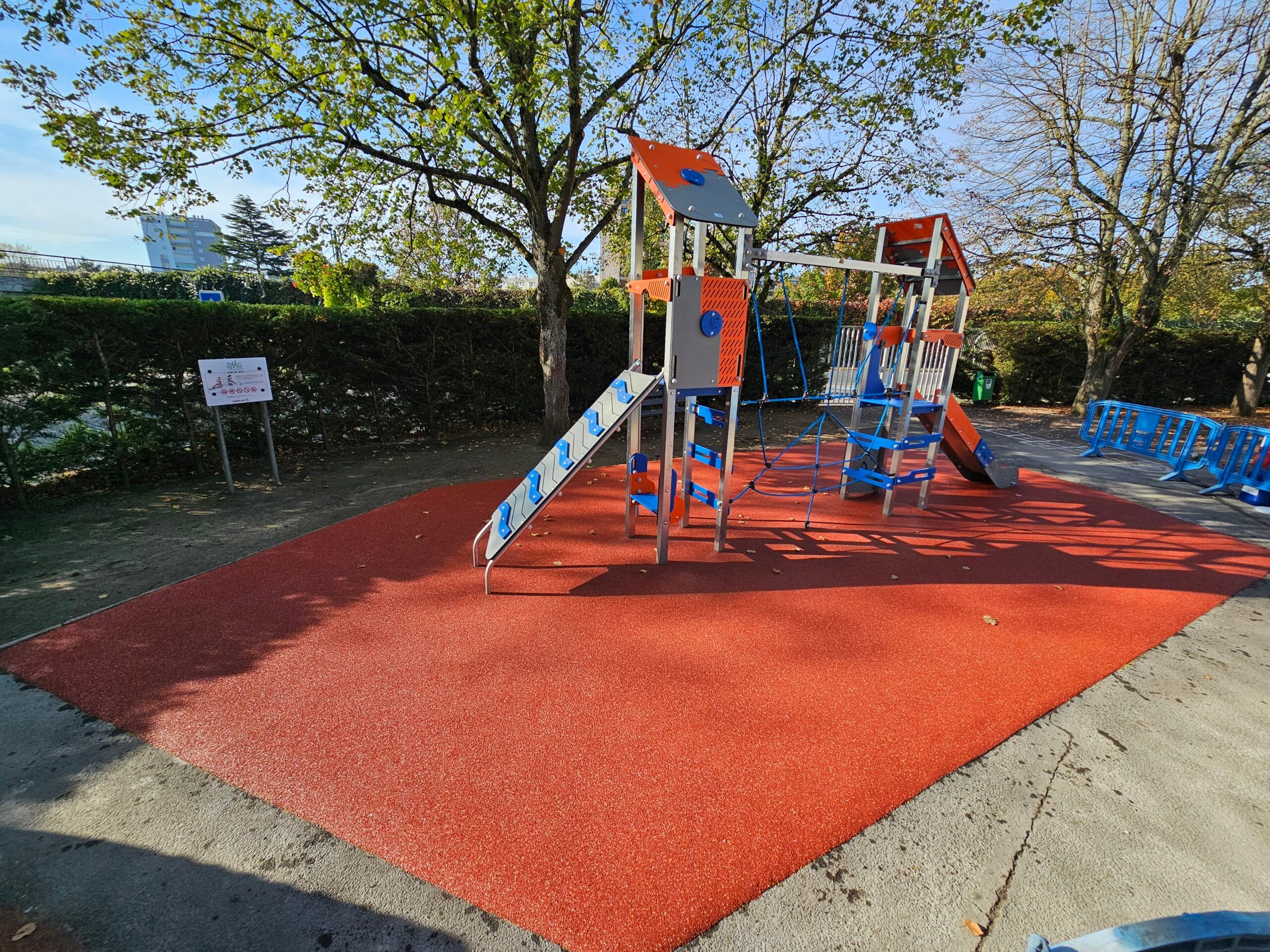 Structure de jeu avec toboggan sur sol amortissant EPDM rouge et sable