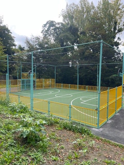 Terrain multisport avec marquage sportif vert et jaune, panier de basket