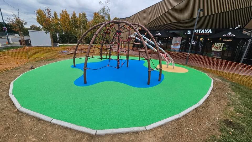 Structure d'escalade avec filet et toboggan sur sol amortissant bleu et vert