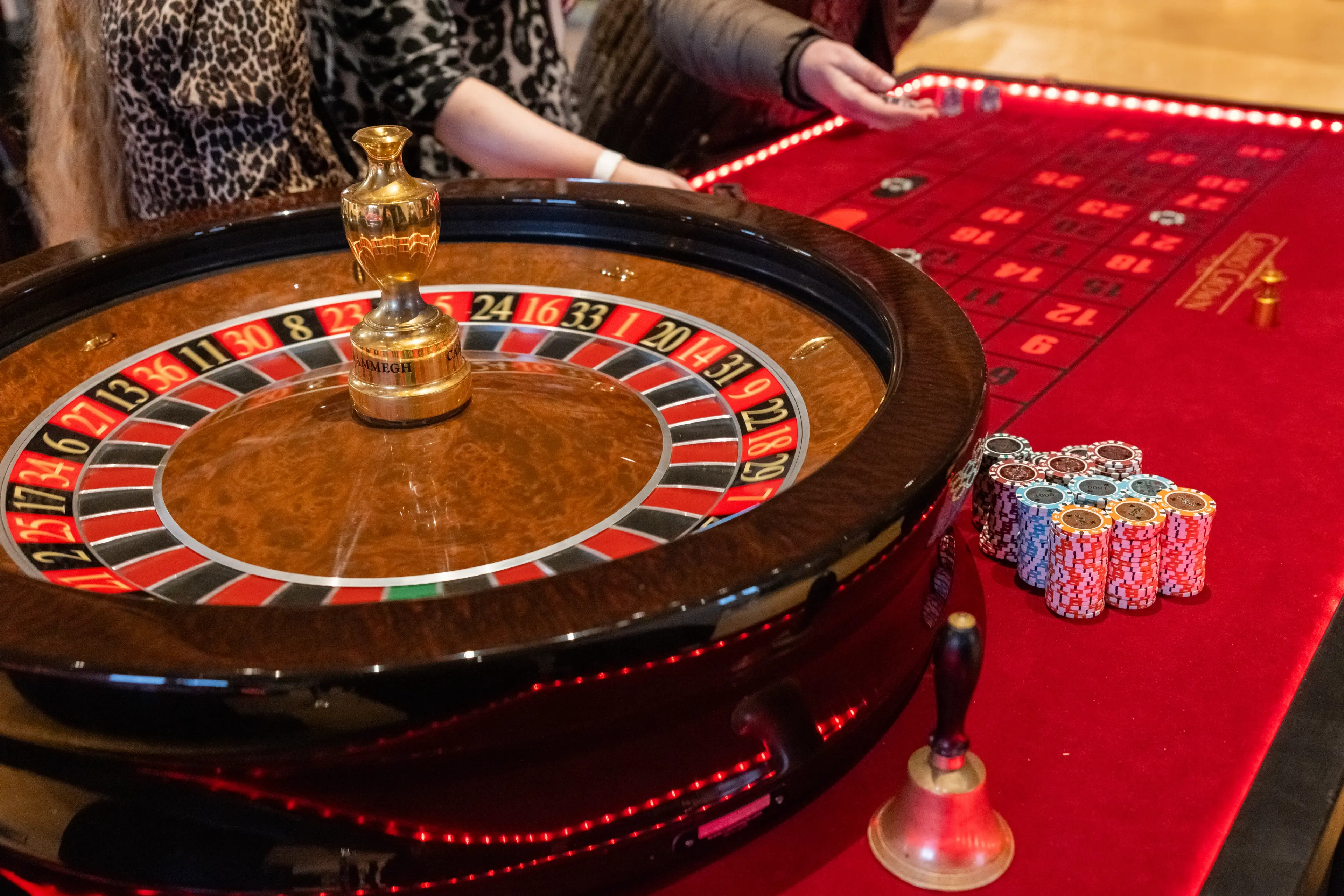 Casino Crown roulettehjul med chipstabler og klokke på rødt bord