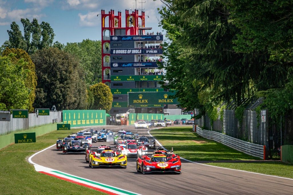 Partenza della 6 Ore di Imola: le Hypercar in gruppo sul rettilineo, con una Ferrari rossa e una gialla in testa