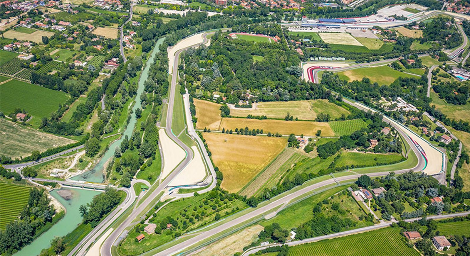 Veduta aerea del circuito di Imola tra campi coltivati, boschi e un fiume