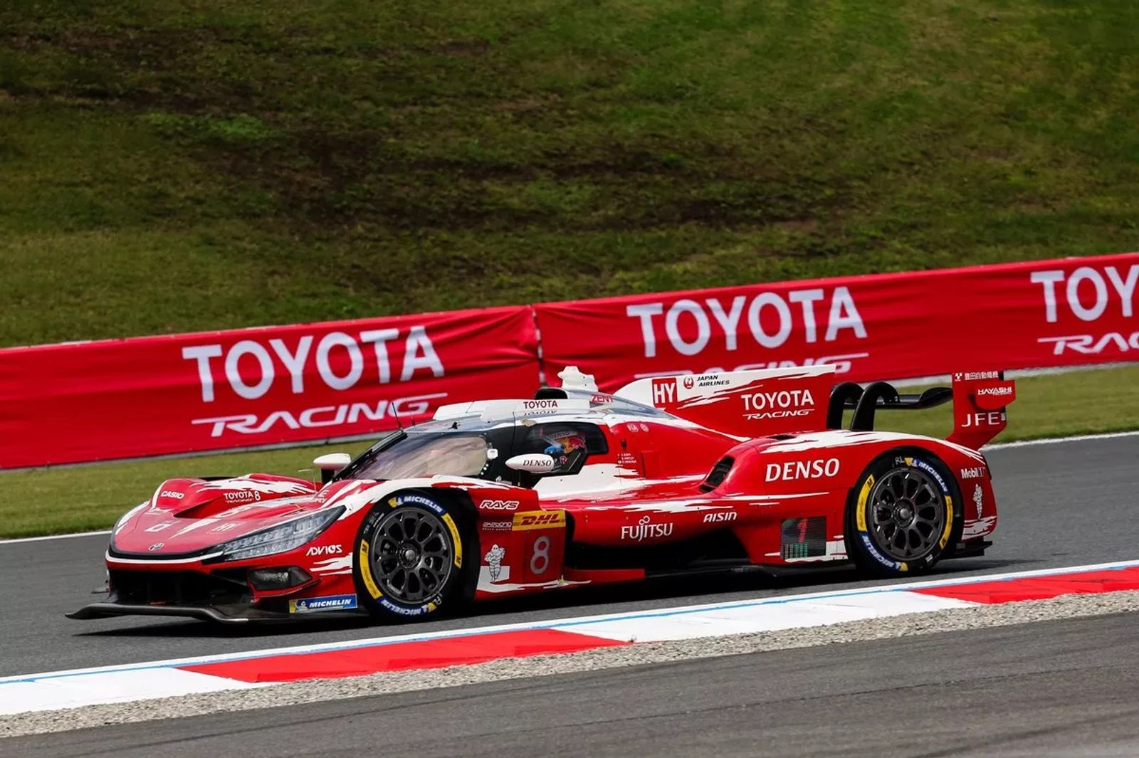 Hypercar Toyota rossa numero 8 in pista, davanti ai cartelloni Toyota Racing