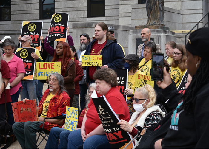 Tenant advocates gather with signs calling for safe, clean, affordable housing