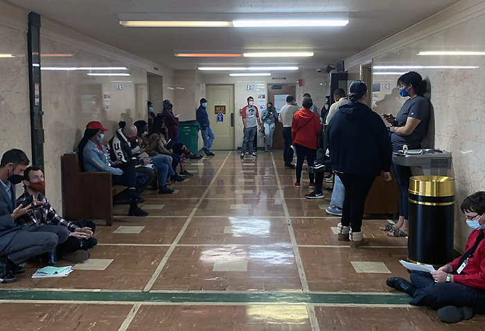 People wait in a courthouse hallway during the 2021 housing crisis