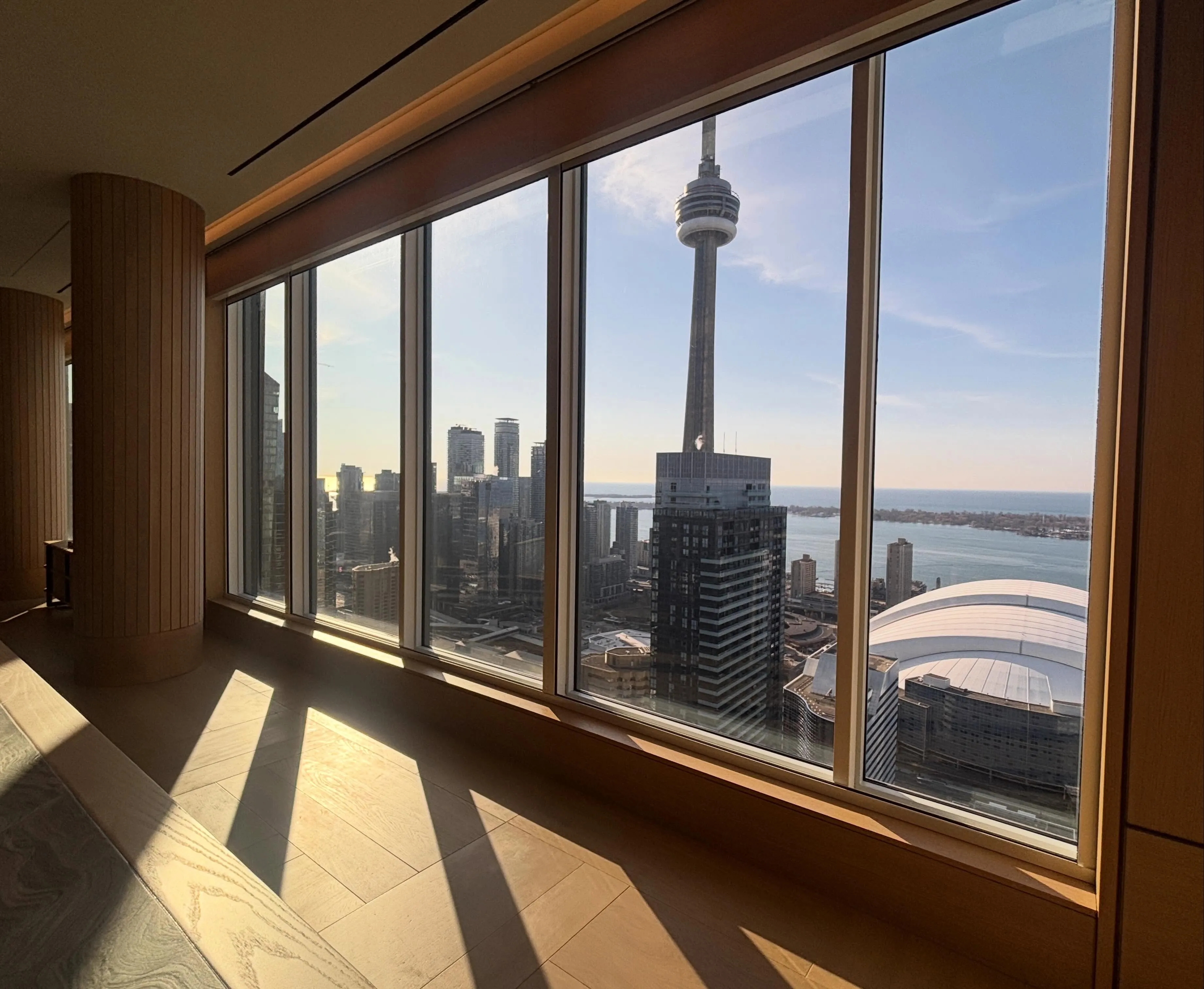 A high-floor interior with floor-to-ceiling windows overlooking the CN Tower and the Toronto skyline
