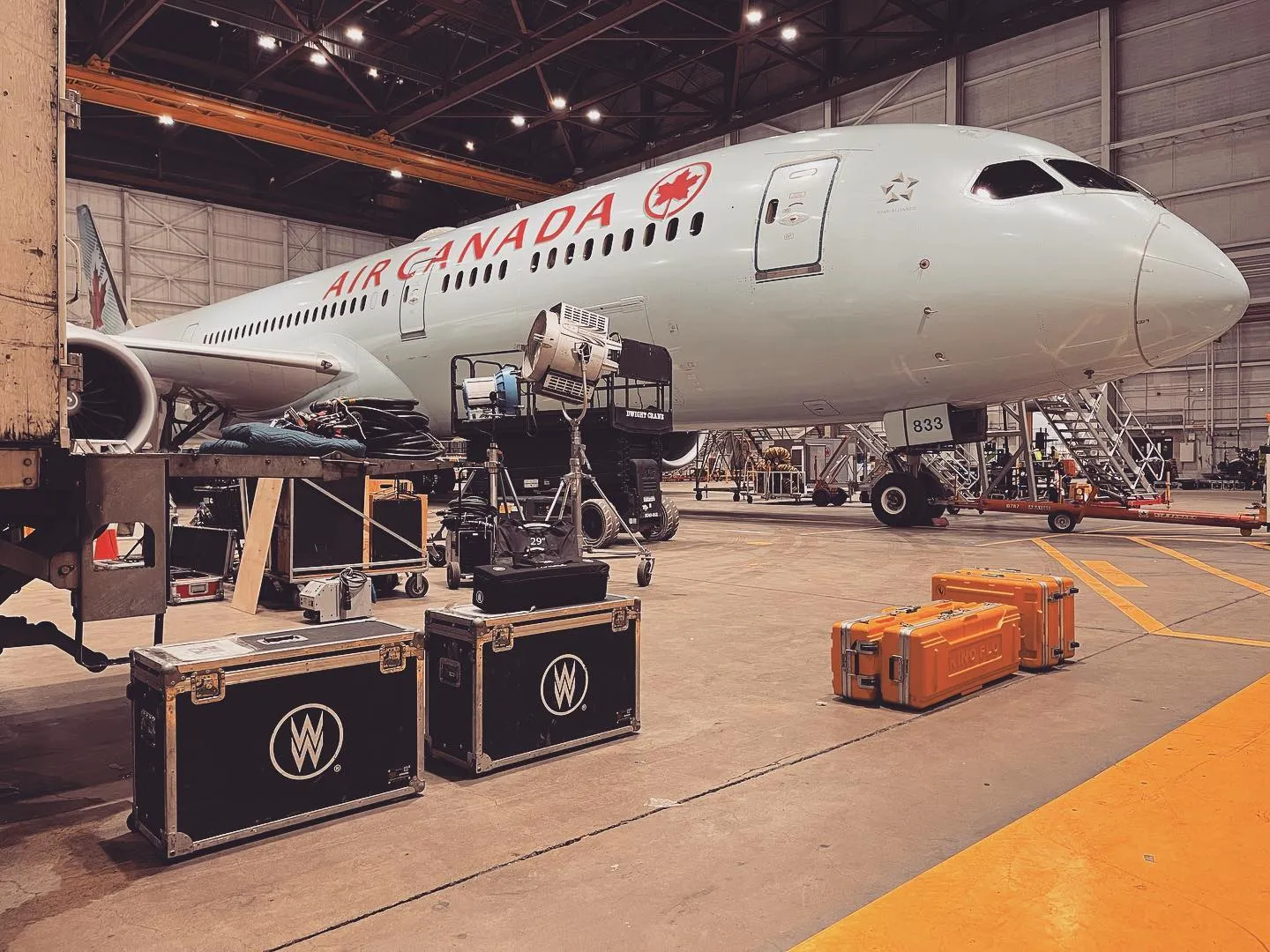 An Air Canada aircraft in a hangar prepped for a film shoot, with production lighting and equipment cases