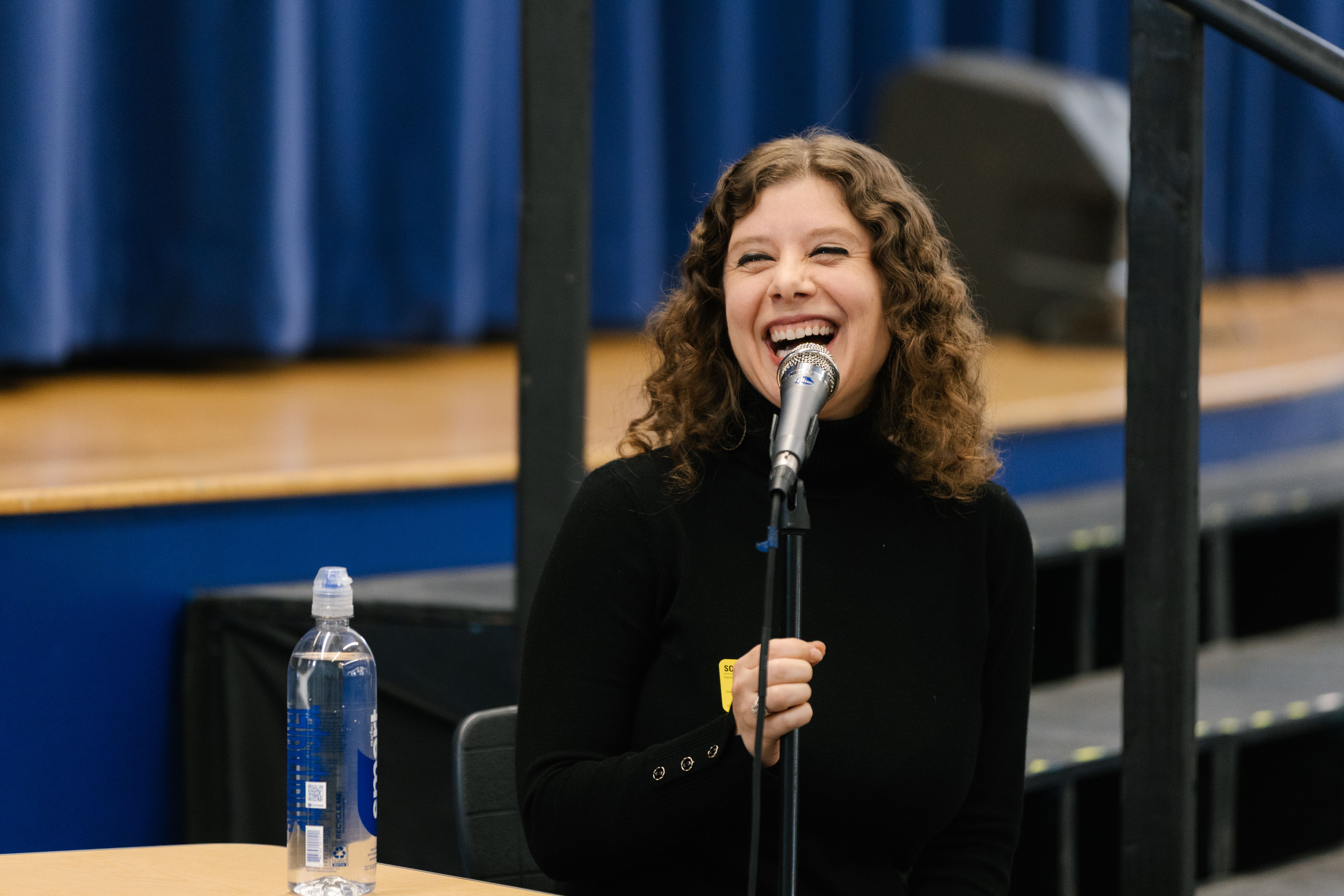 Romina smiling and laughing while speaking at an event