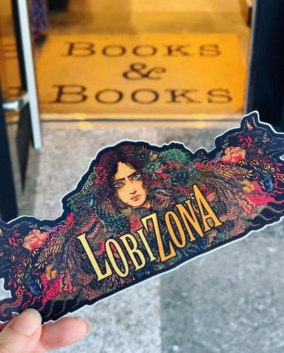 A hand holding the 4/1/2020 edition of Booklist, which features Lobizona as the cover image.