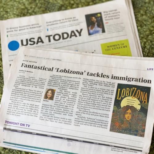 A hand holding the 4/1/2020 edition of Booklist, which features Lobizona as the cover image.