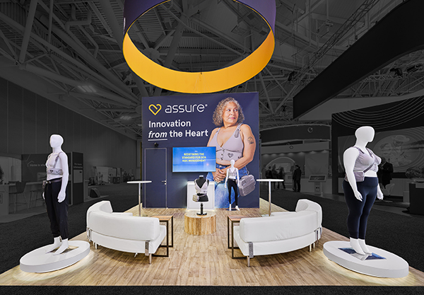 Kestra tradeshow booth with two mannequins wearing the ASSURE garment