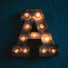 the letter a is lit up on a blue wall .