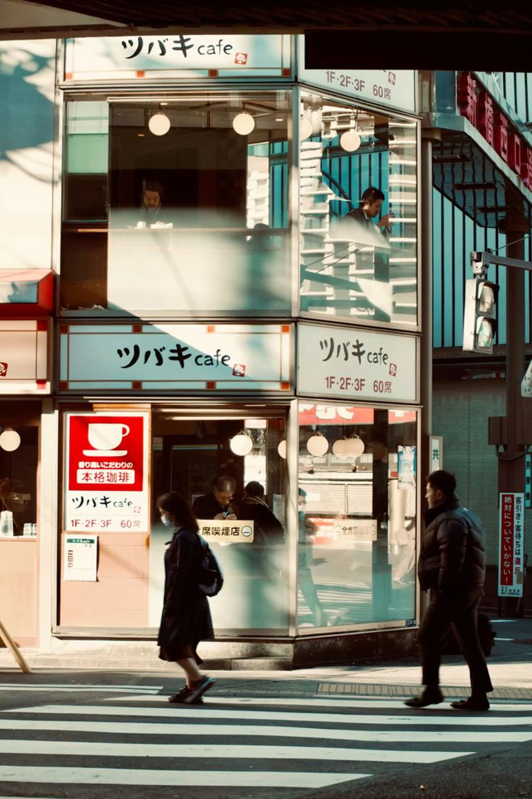 Pedestrians crossing outside a café in Tokyo.