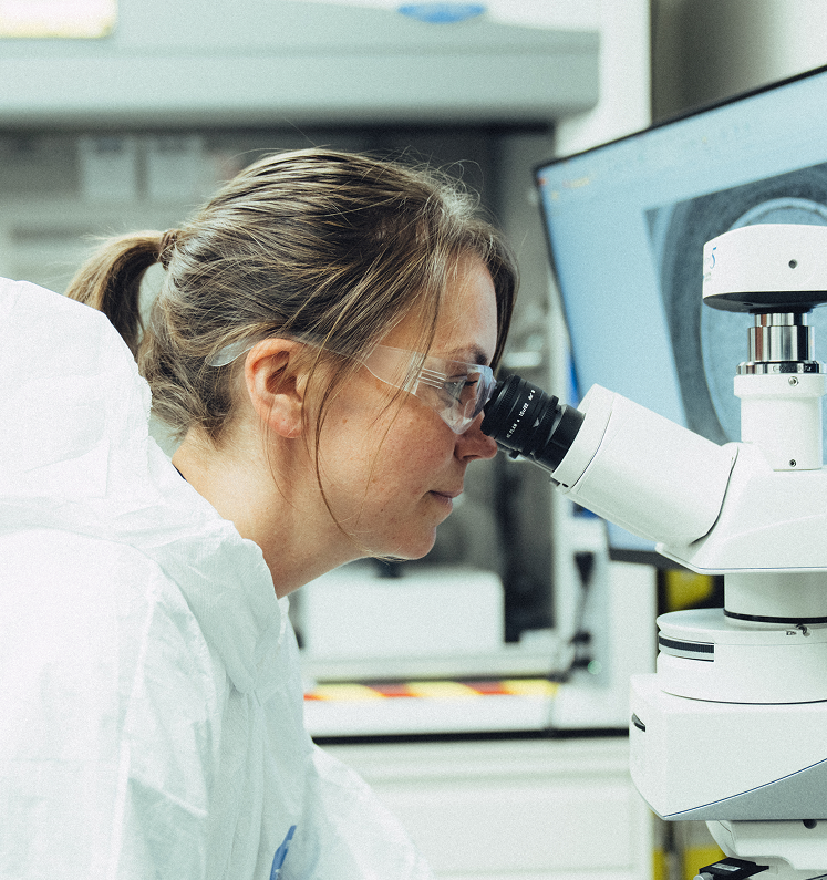 A scientist looking into a microscope