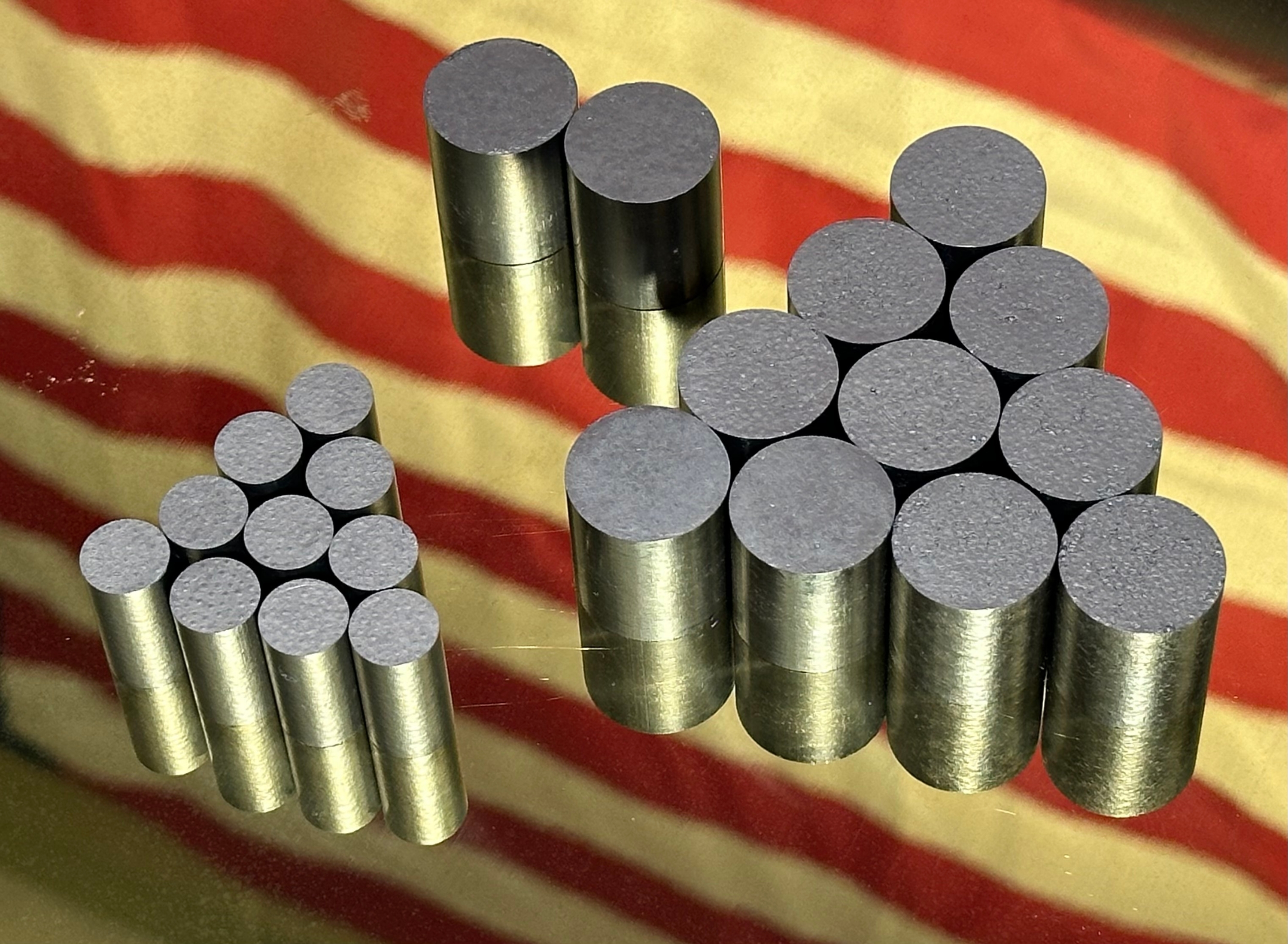 TRISO fuel pellets in a hand with a glove on