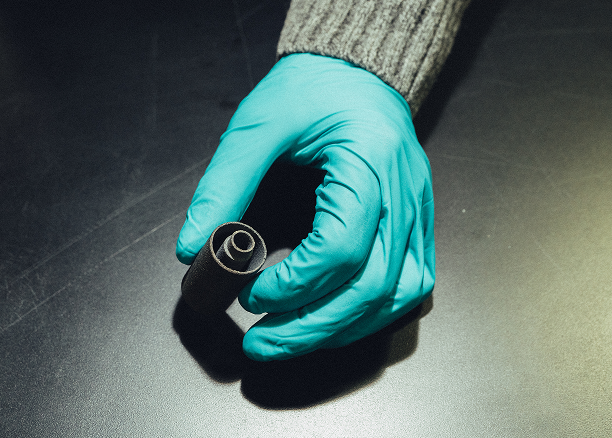 a TRISO component in a gloved hand