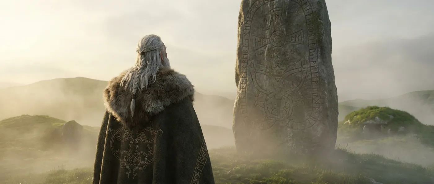 Wikingerkönig Harald Blauzahn von hinten gesehen vor einem großen Runenstein in nebliger Morgenlandschaft