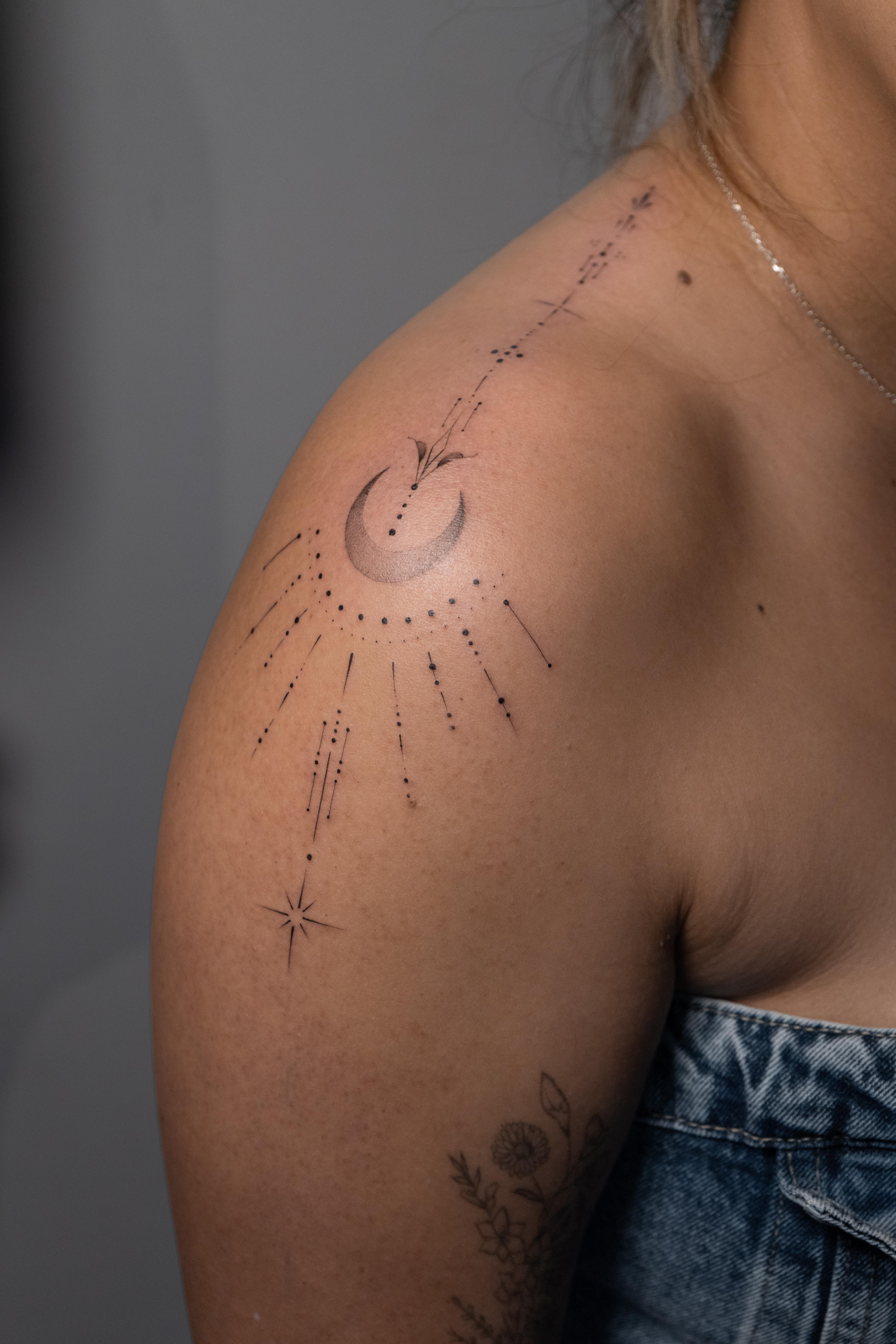 Shaded crescent moon with fine-line constellations across the shoulder