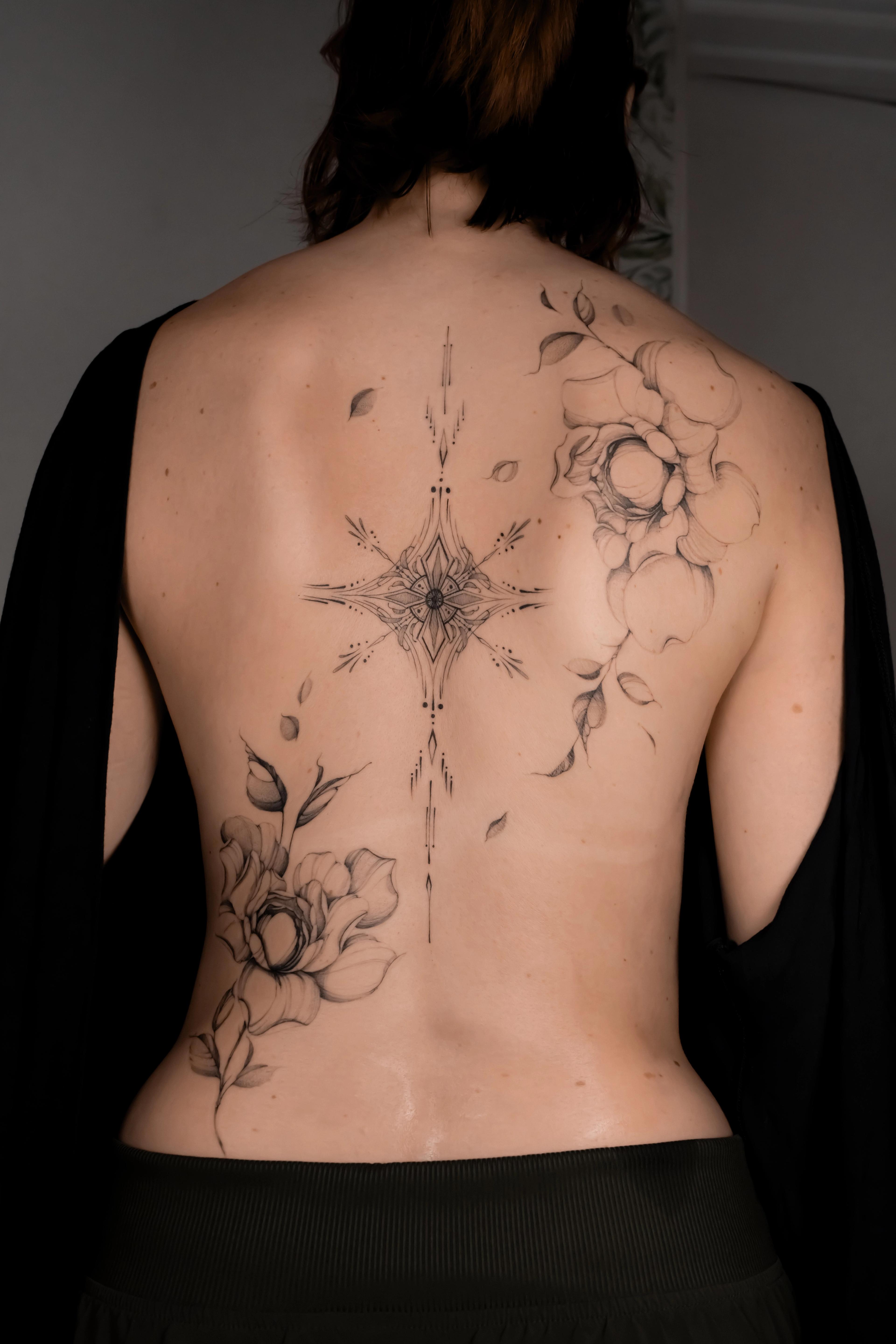 Fine-line ornamental spine piece between two floral studies