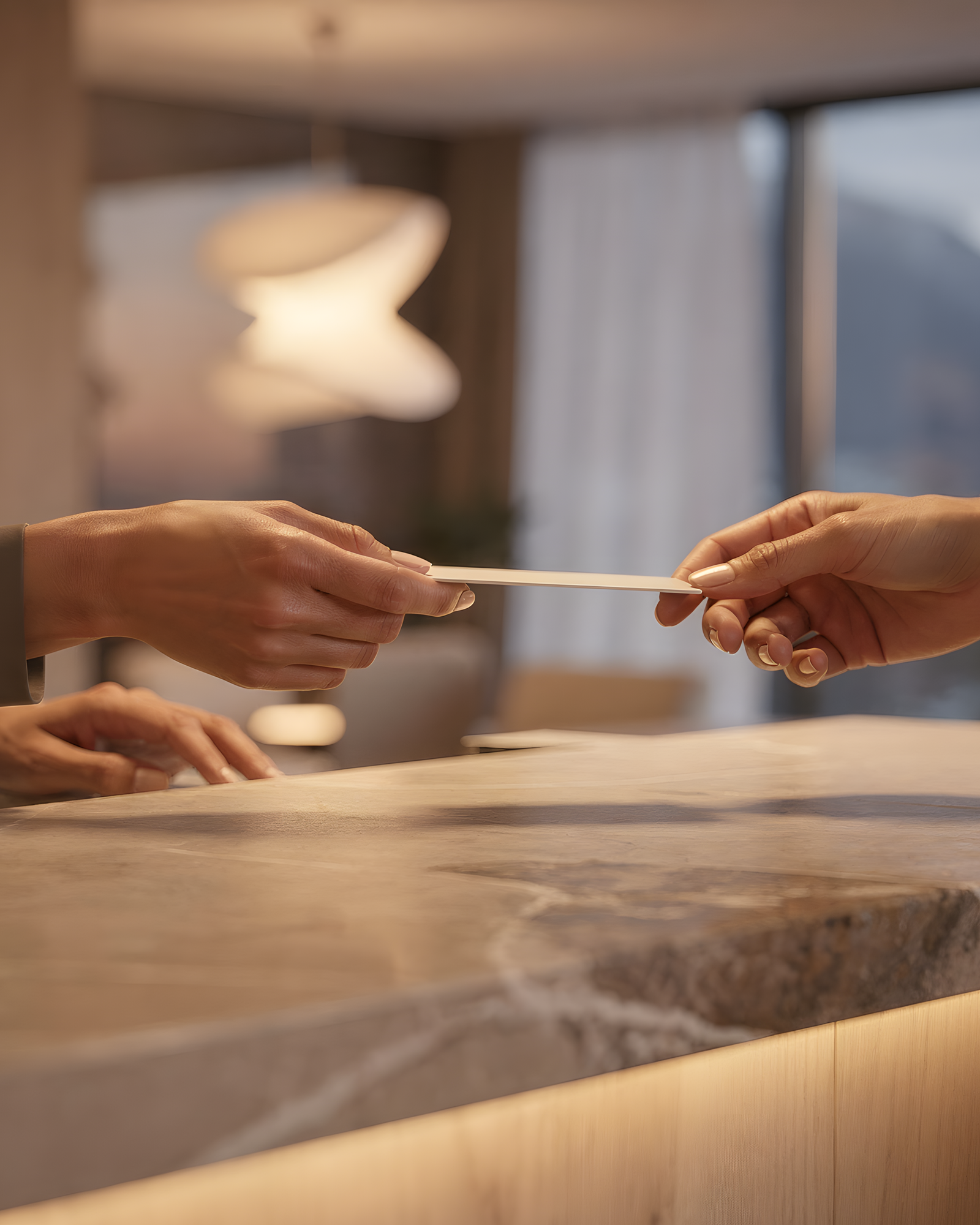 Übergabe einer Schlüsselkarte über den Empfangstresen eines Hotels
