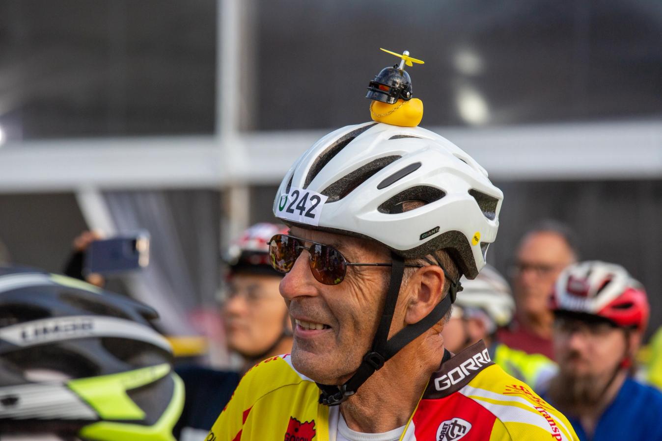A man with a small rubber duck on his helmet