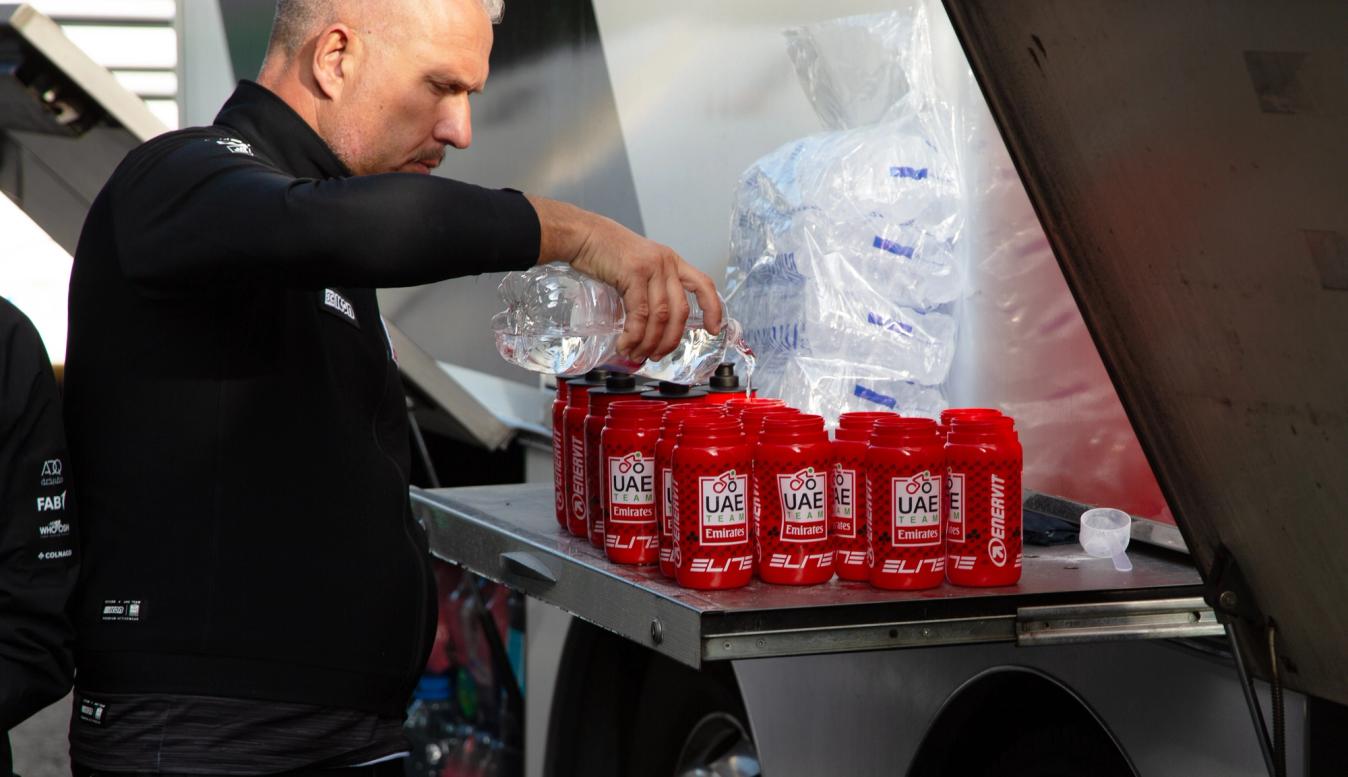 A UAE Team Emirates team member fills water bottles ahead of stage 4 of the Vuelta a Espana