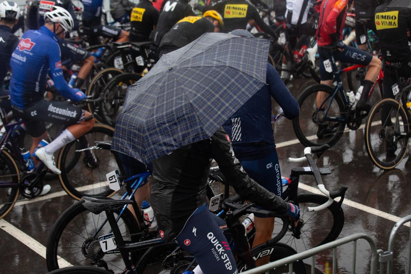 Pieter Serry takes cover under an umbrella before stage 2 of the Vuelta a Espana