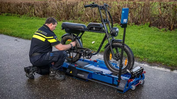 A police officer prepares an e-bike for testing