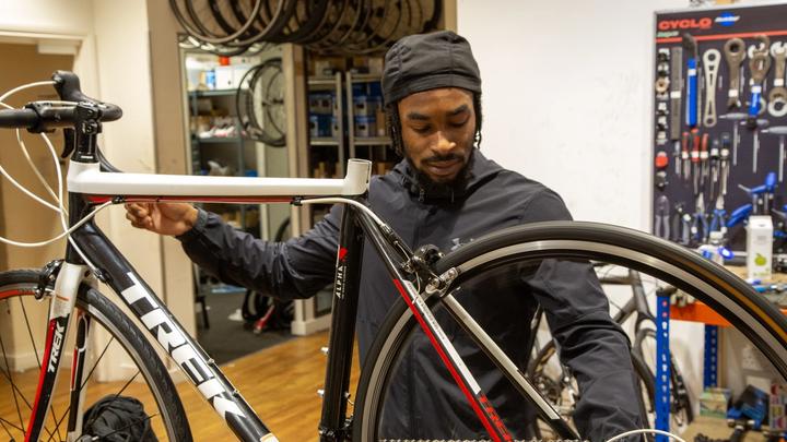 Trey, a mechanic at XO Bikes, prepares a Trek road bike for sale