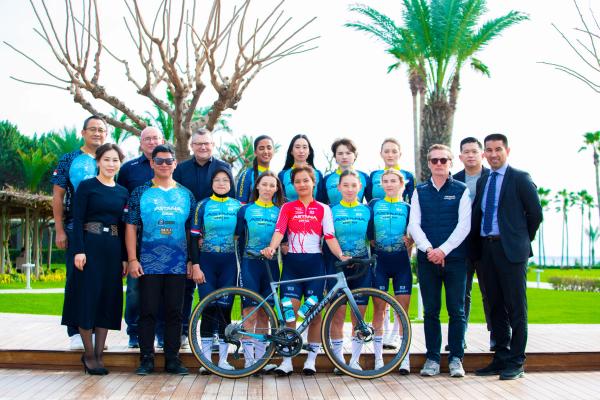 Assem Kunakbayeva (front left) stands alongside the riders and management staff of Astana Dewi