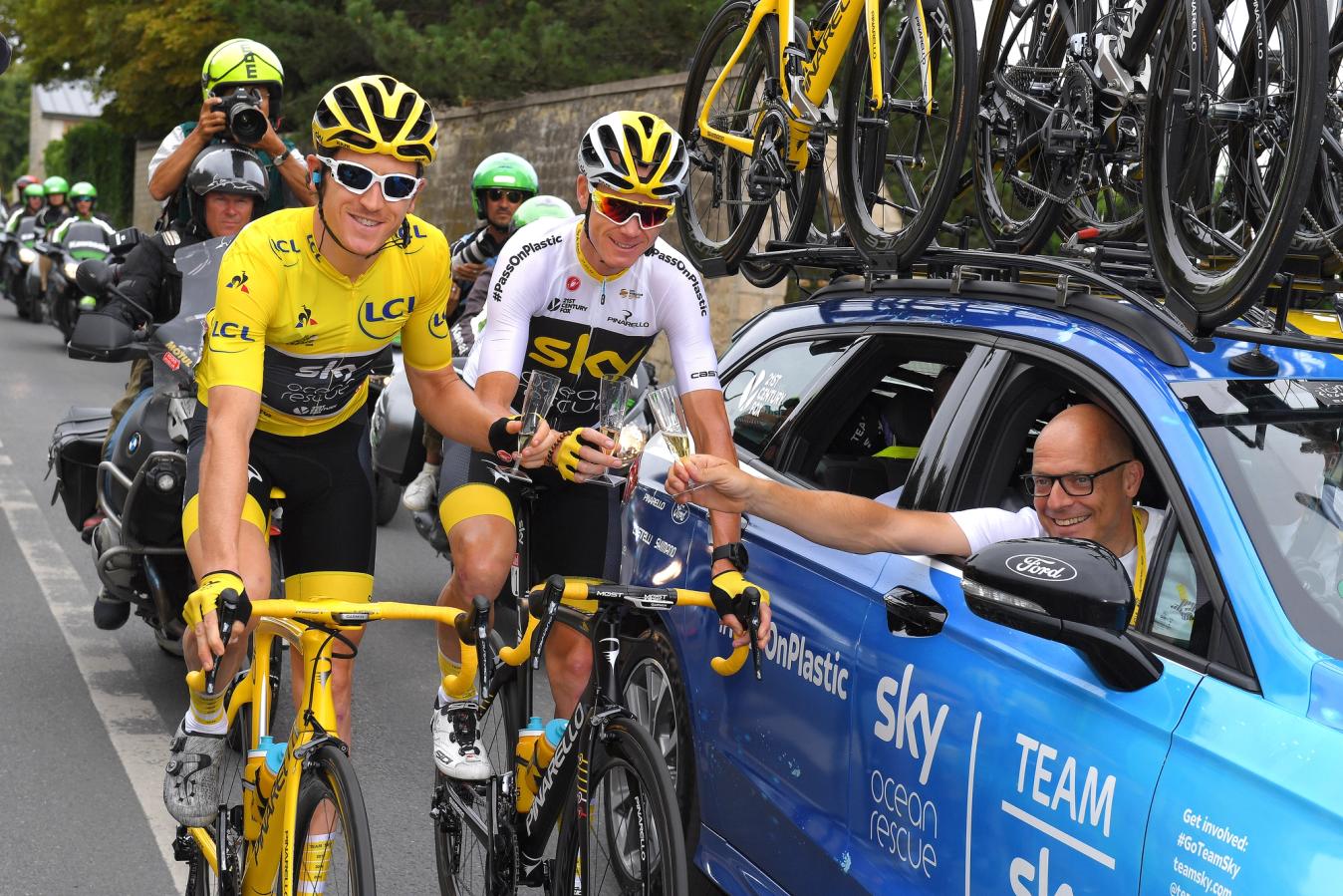 Geraint Thomas (left), Chris Froome (centre) and Brailsford (right) toast a job well done at the 2018 Tour de France