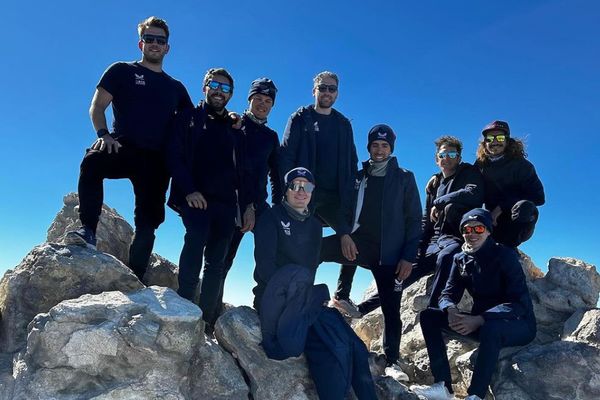 Ineos Grenadiers riders and staff stand proud atop the summit of Mount Teide