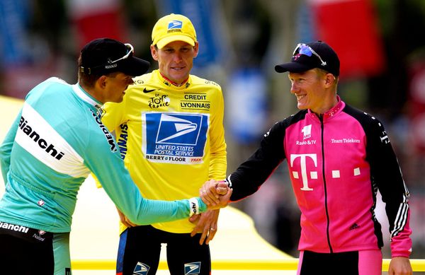 Lance Armstrong watches on as Jan Ullrich (left) and Alexandre Vinokourov shake hands on the final podium of the 2003 Tour de France