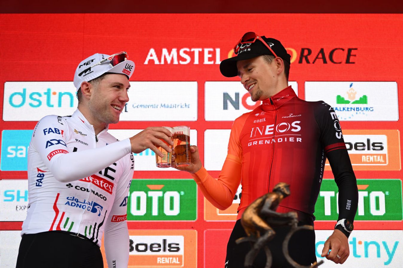 Marc Hirschi (left) shares an Amstel beer with Tom Pidcock on the podium of the Amstel Gold Race