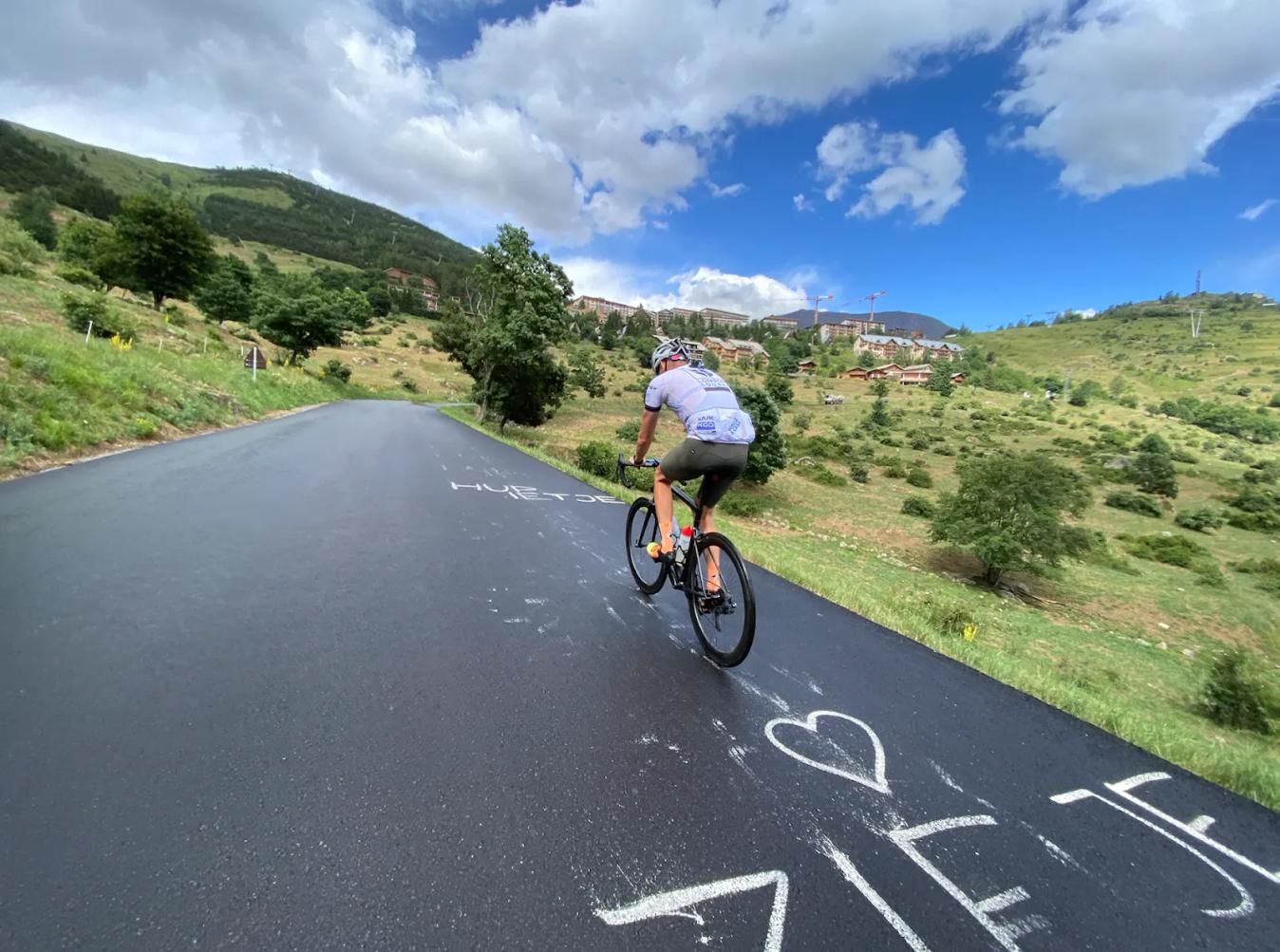 Ottilie Quince takes a picture of her riding partner Simon as they both climb Alpe d'Huez.
