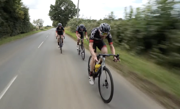 Three cyclists on a road with one dropping behind