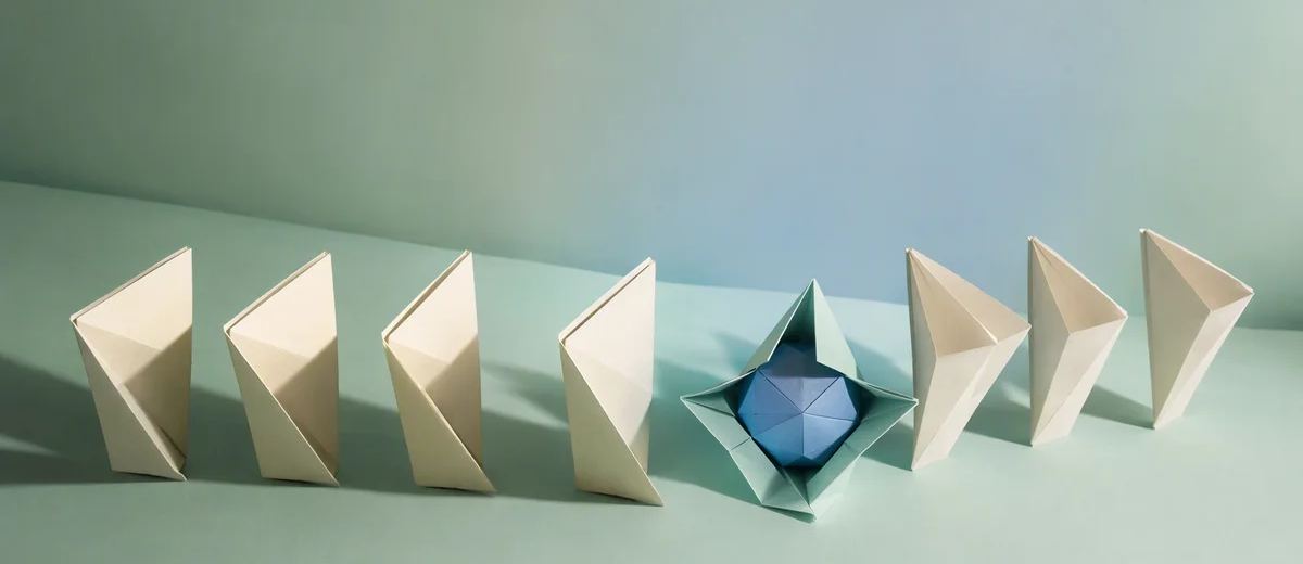 A row of ivory folded paper forms surrounds an open mint fold containing a blue geometric shape.